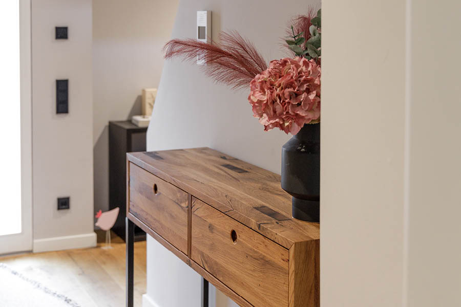Detailaufnahme Konsolenschrank: Altholz-Front und Deckplatte mit Vase; geölte Oberfläche, feine Struktur, klare Kante, reduzierte Optik. Aktuelles – Trends – News im November 2025 | Möbeltischlerei woodendesign | Tischlerei Möbeltischler Möbelmanufaktur Hamburg