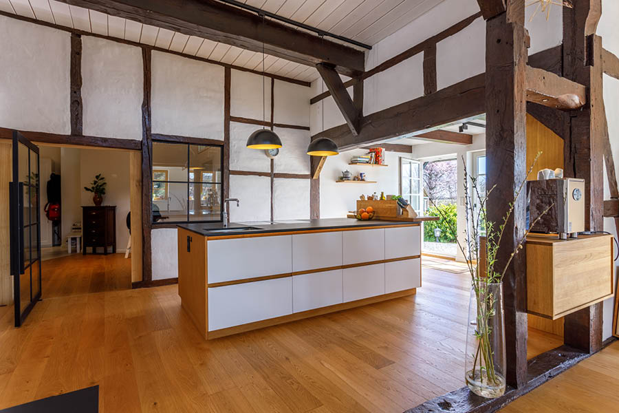 offene Küchengestaltung im lichtdurchfluteten Fachwerkhaus | Kücheninseln, auch Küchenblock oder freistehende Kochinsel genannt, sind das Zentrum moderner Küchen. Die Möbeltischlerei woodendesign, Ihr Küchenexperte / Küchenprofi in Hamburg berät Sie gern.