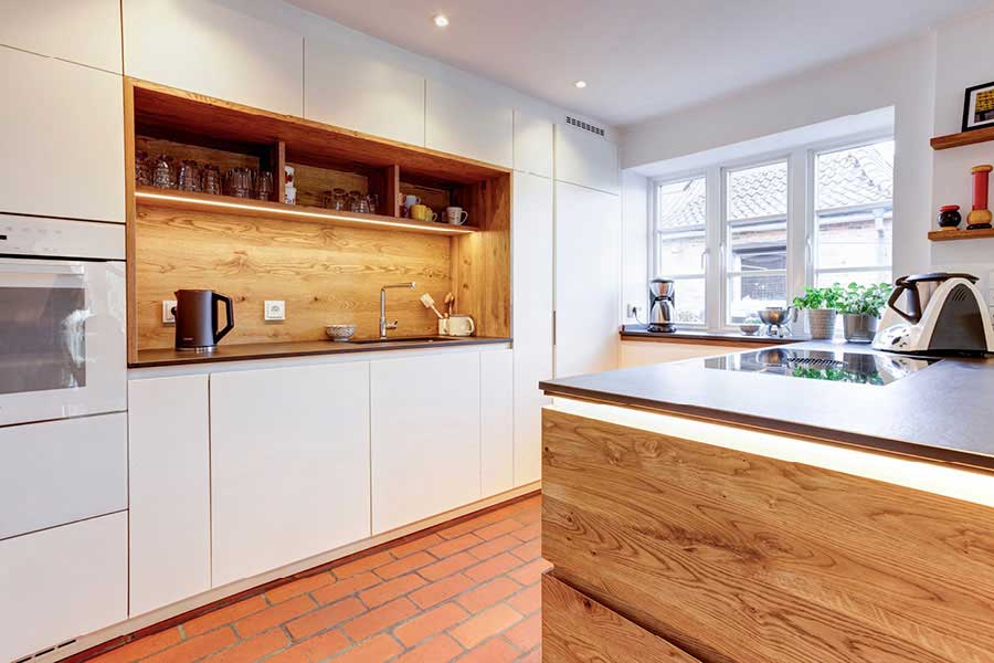 Massivholzküche mit indirekter Beleuchtung, grifflosen, weißen Fronten und beleuchteten Schubladen | Möbeltischlerei woodendesign aus Hamburg